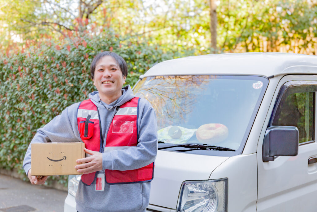 車の前で荷物を持つ沖田さん