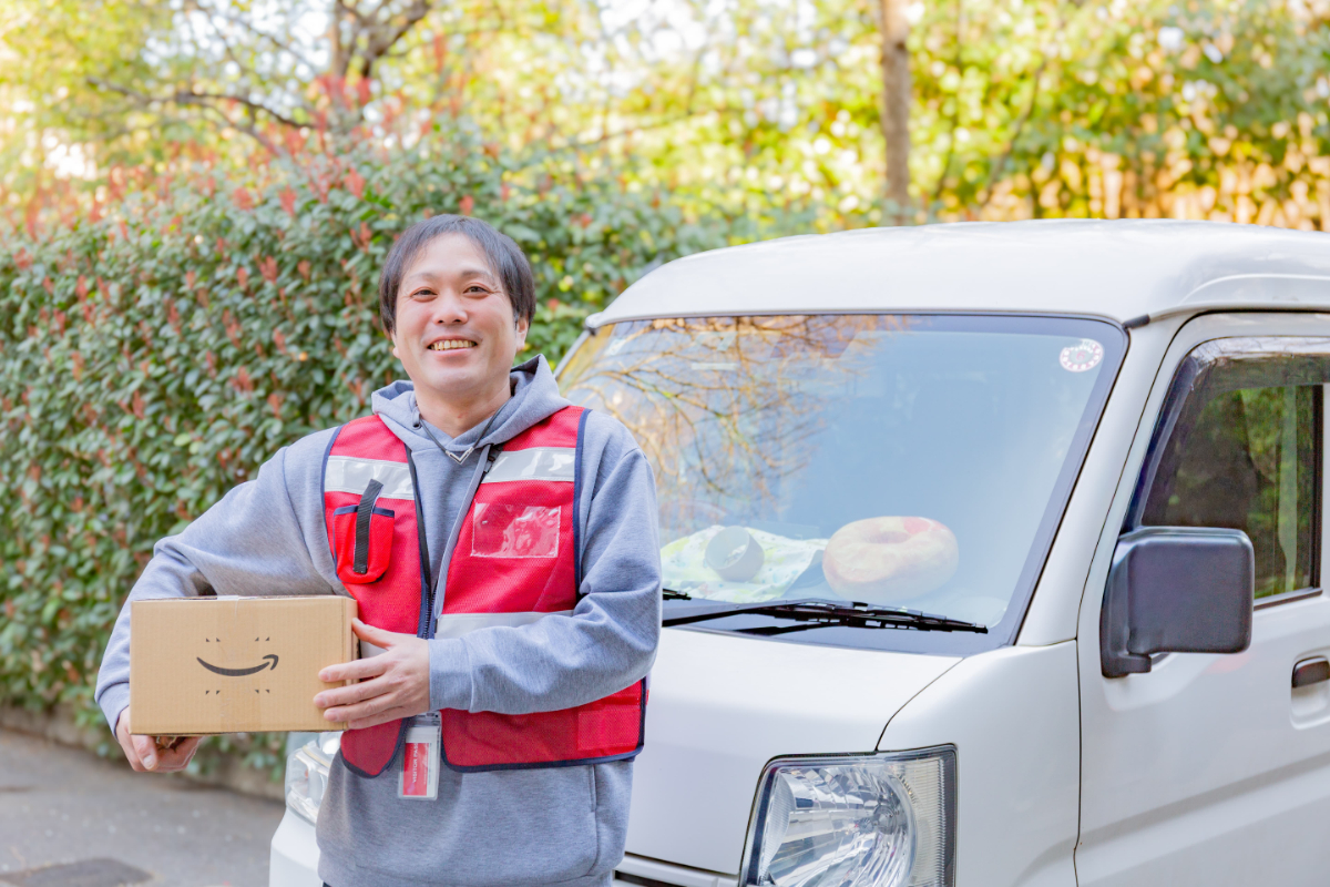 車の前で荷物を持つ沖田さん