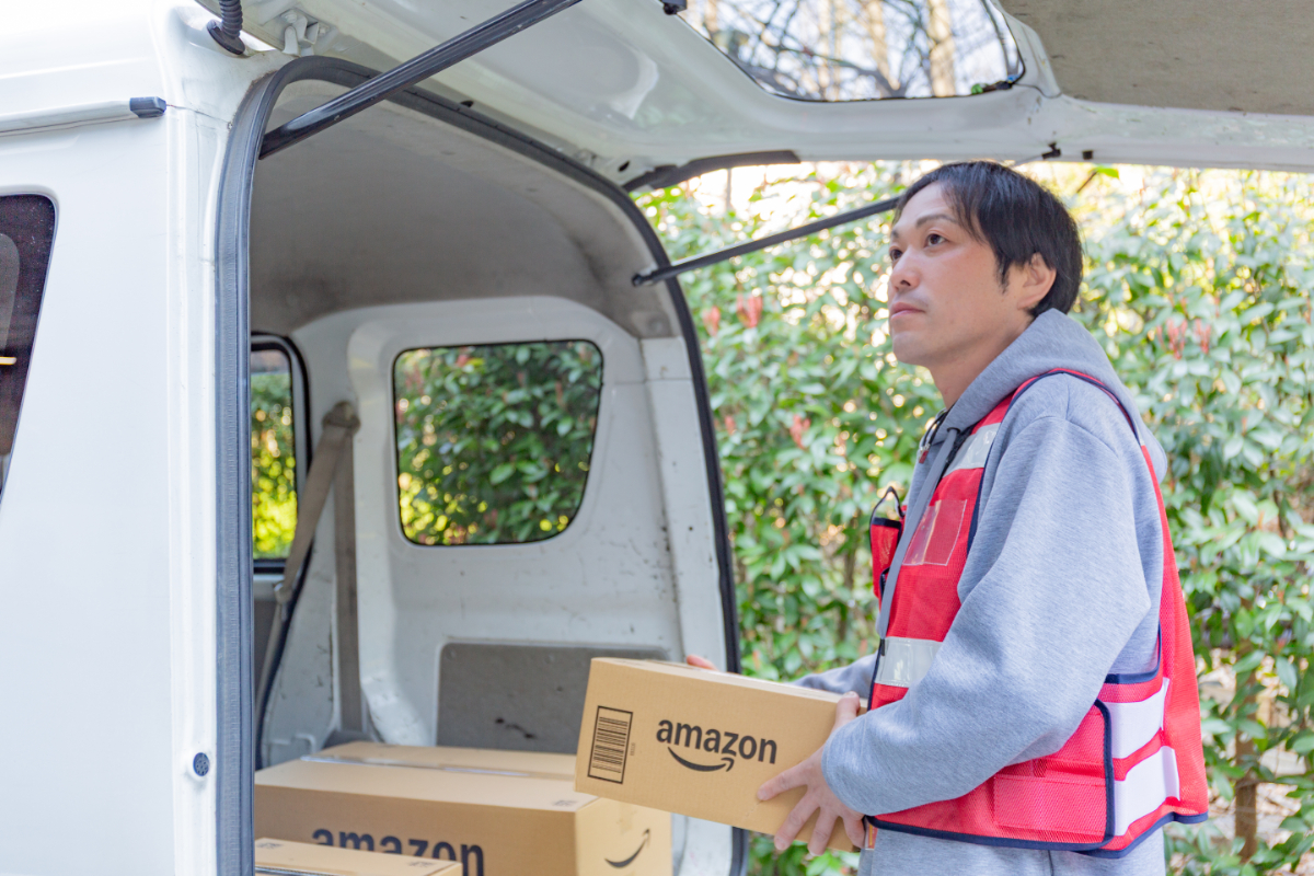 車のバックドアを開けて荷物を持つ沖田さん